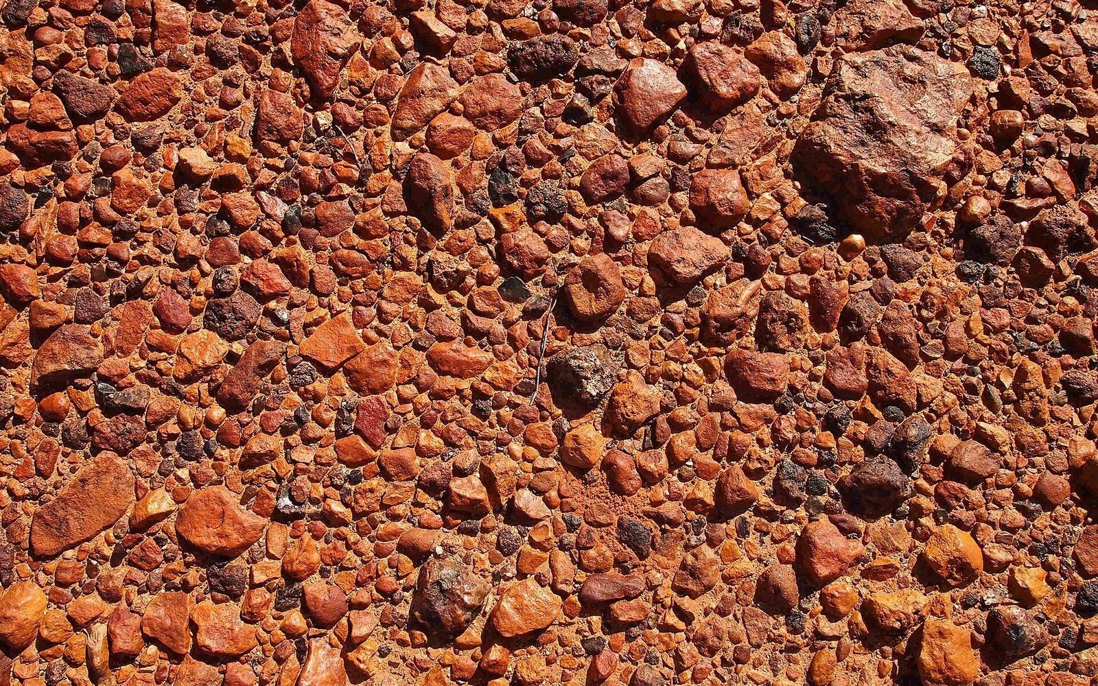 Close-up of reddish-brown desert pavement made of tightly packed, interlocking gravel and stones